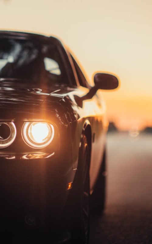 luxurious-car-parked-highway-with-illuminated-headlight-sunset